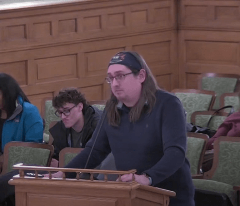 A photo of Alexander Dewitt speaking at a city commission